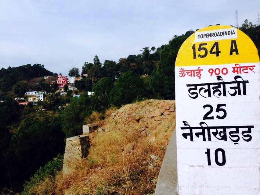 Milestones in the hills â€” Dalhousie 25 km, stamped with our sticker. â€” Himachal Pradesh